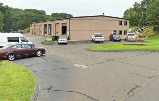 Wide view of D&R Automotive with open service bays and customer vehicles