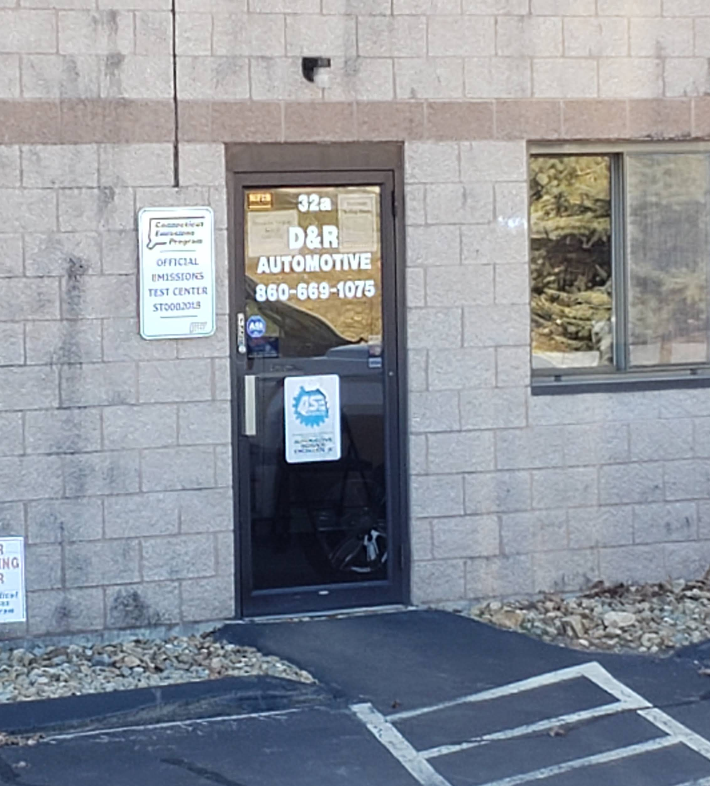 D&R Automotive front entrance and Official Emissions Test Center sign